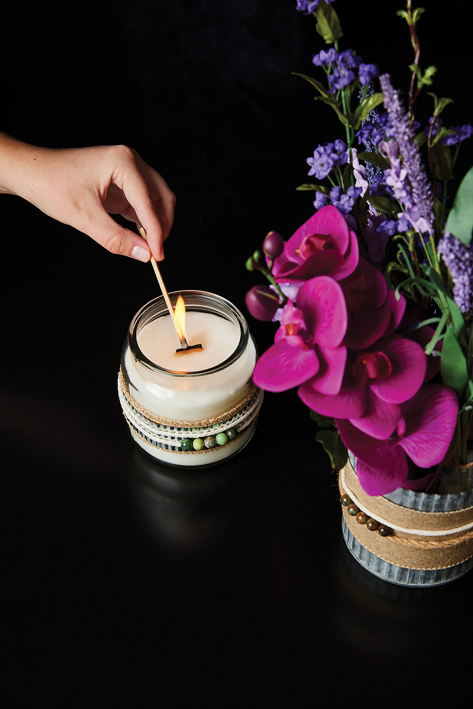 Hand lighting a Blooming Brightly candle.