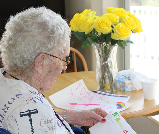 A senior at Woodbury Senior Living reads a handwritten holiday letter.