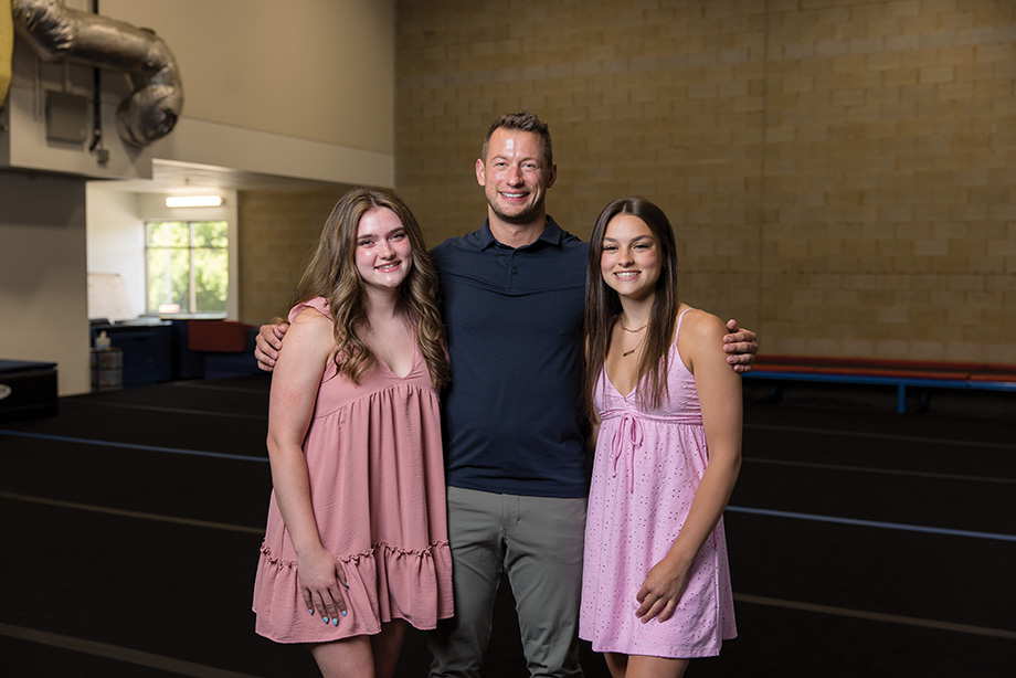 The Tumbling Club founder Javis Borgh works with ERHS students and alumna, including Gabby (left) and Riley Billmeyer (right).