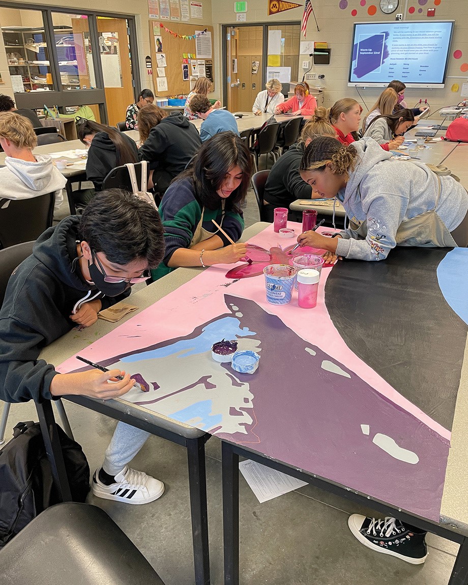 ERHS art students blocking in larger areas of color with Nova mural paint. 