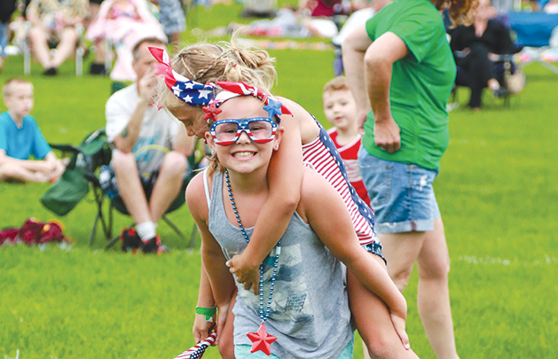 Two girls decked out in red, white and blue celebrate the Fourth of July at the Woodbury fireworks show.