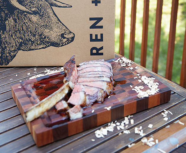 A tomahawk steak from Ren + Bos sits on a TAZ cutting board.