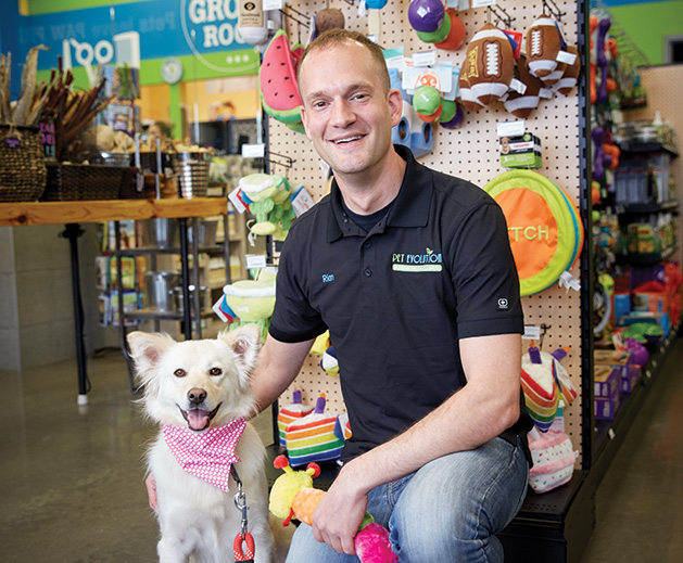 Rian Thiele, co-owner of Pet Evolution in Woodbury and Arden Hills, poses with a dog.
