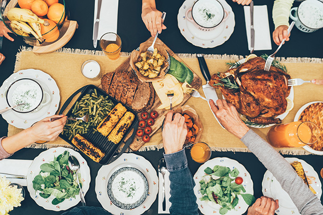 A family gathers around a table for Thanksgiving dinner