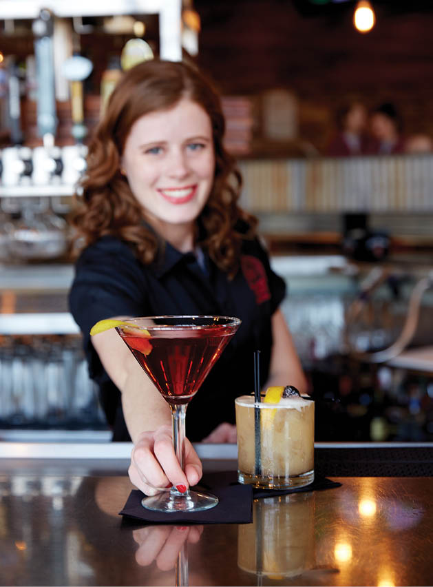 (Alyssa Ranking serves a pomegranate Cosmo and an amaretto sour at Tamarack Tap Room; Photo by Tate Carlson)