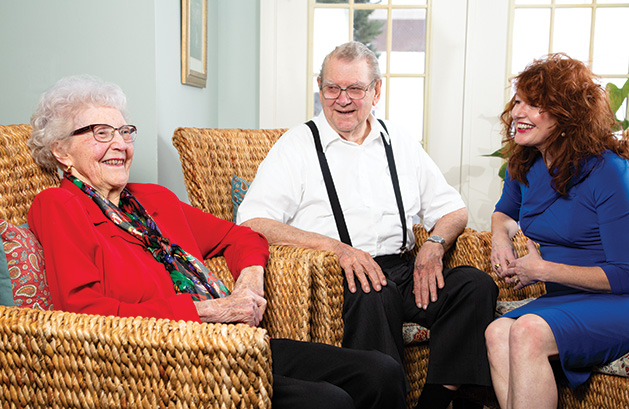 Woodbury Senior Living Columnist Margaret Wachholz sits with two senior residents.