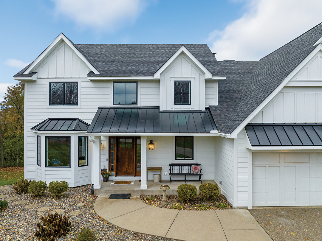 Custom One Exteriors brought a Lake Elmo home back to life with updated white lap siding, a black standing seam metal roof, modern windows and new lighting fixtures.
