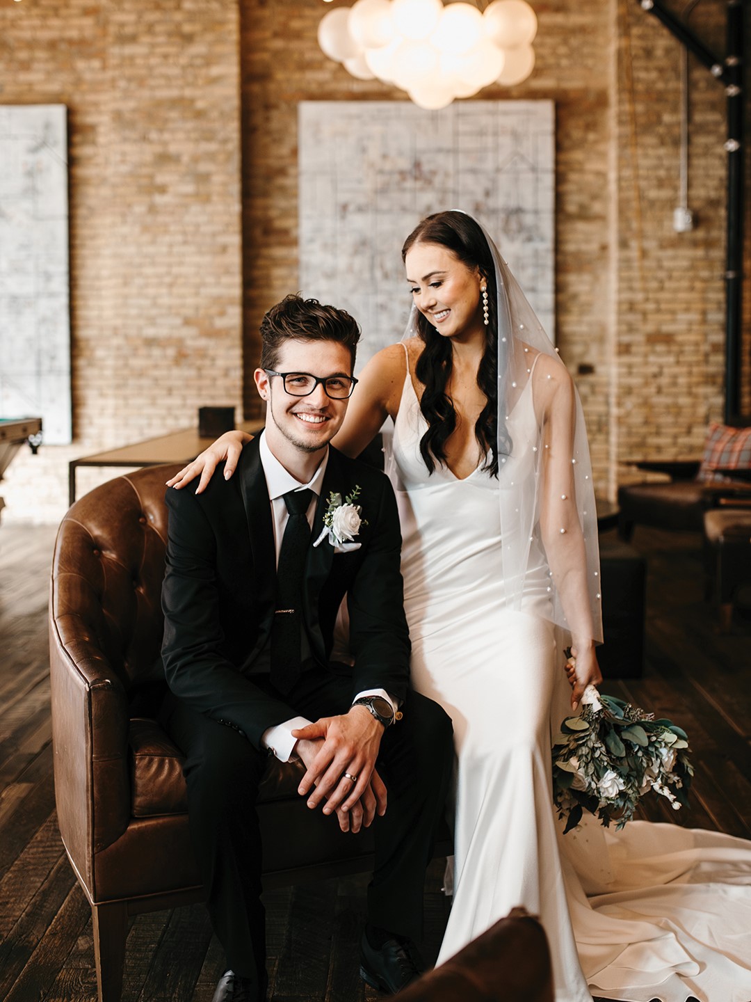 The groom’s suit from St. Paul’s Milbern Clothing Co. included a sophisticated black jacket with satin lapels and a textured floral tie. His look was complete with Calvin Klein Brodie Oxford shoes and a gift from his bride: custom cufflinks adorned with the faces of their pets. Photos: Type & Timber 