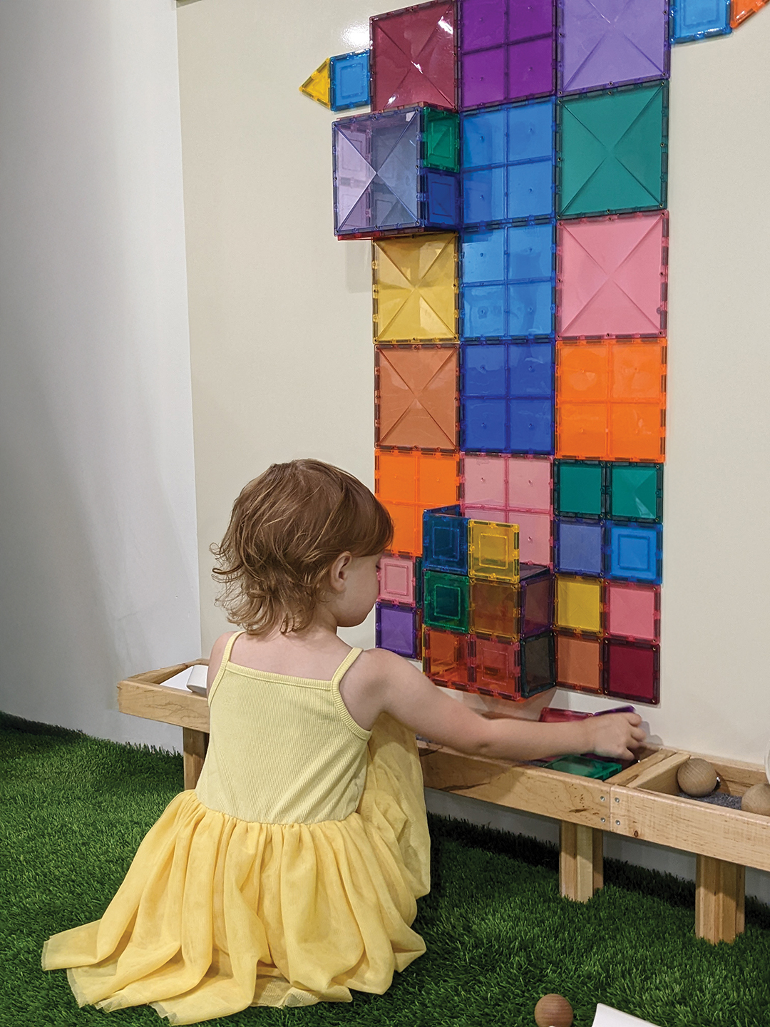 The magnetic tile wall encourages creative play at The Little Village.