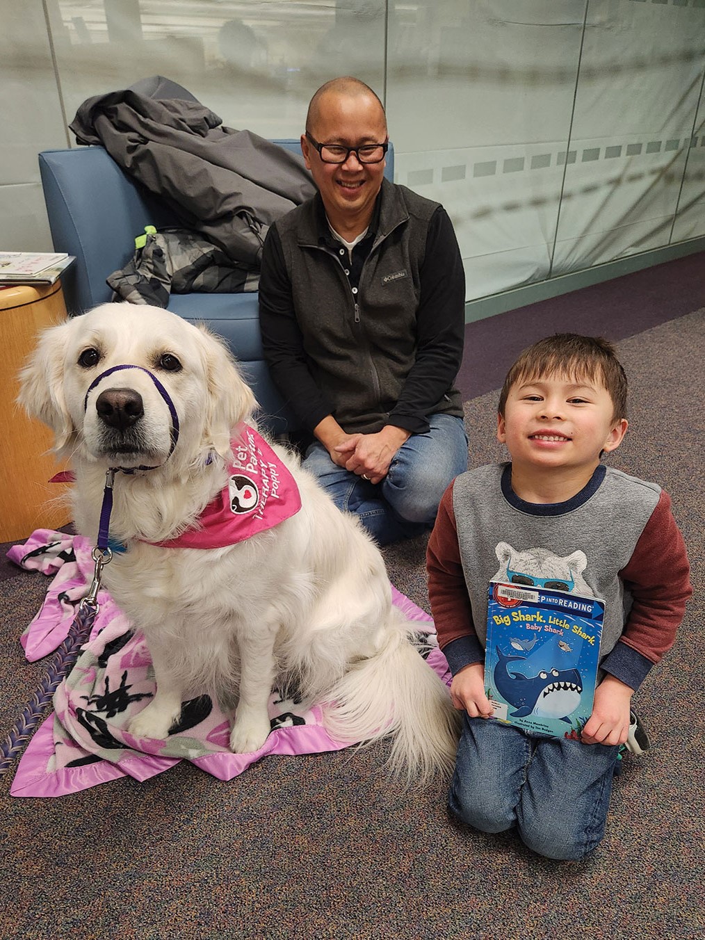 Kai and Thuan Luu enjoy reading to Poppy at the R.H. Stafford Library.
