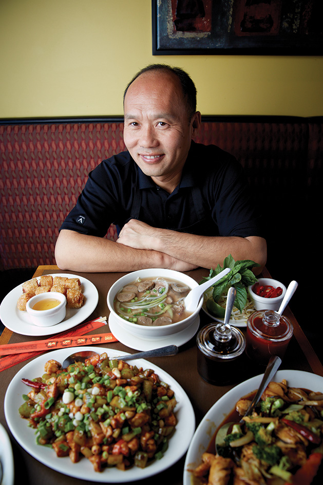 Duc's Restaurant owner Duke Kim sits in front of some of his food.