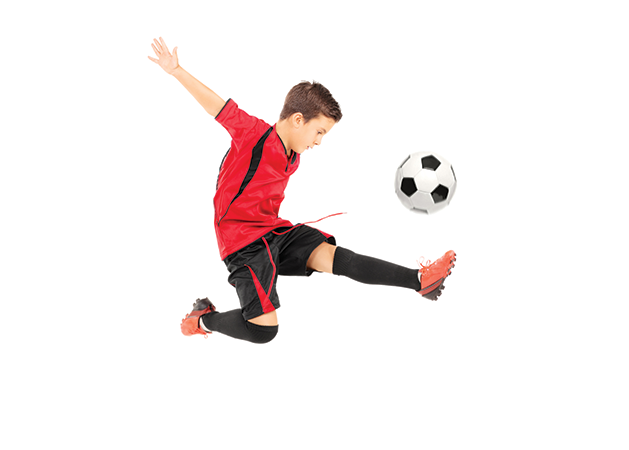 Young boy kicking soccer ball