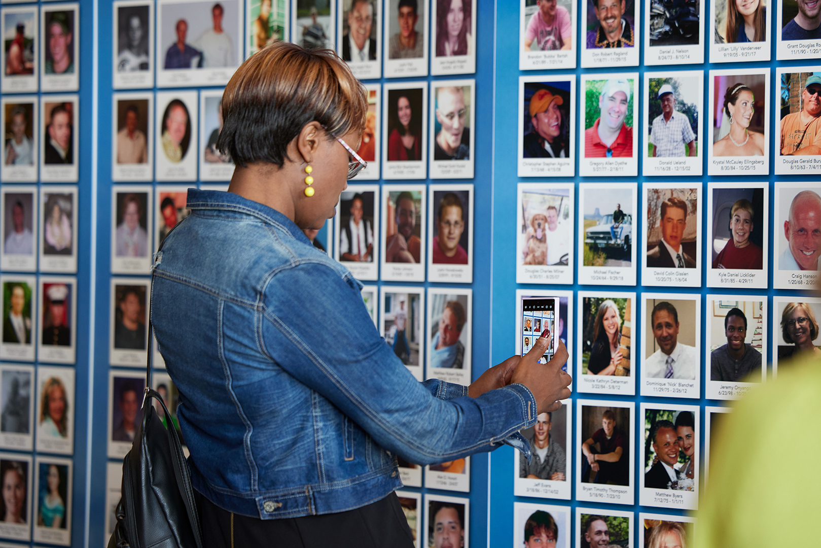Woman adding a photo to the memorial wall.
