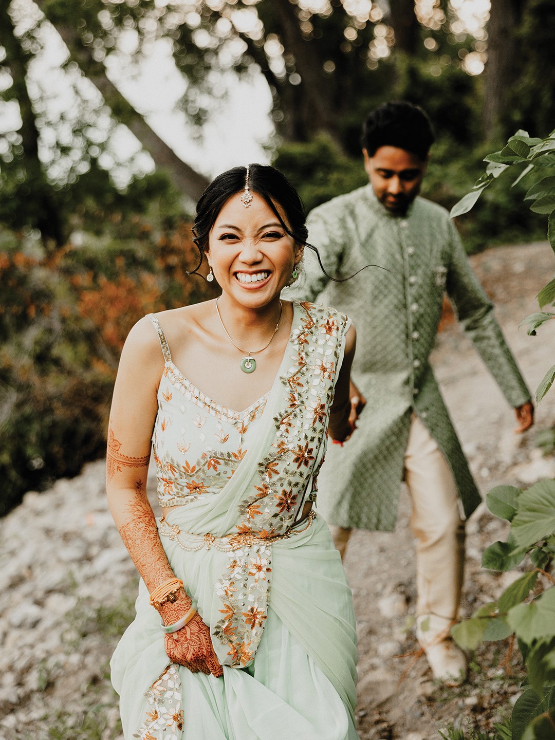 At the reception, the seafoam green shade of Vikram Nagarajan’s kurta and Quynh-Huong Van’s palazzo pant set and draped dupatta was coordinated to match Van’s jade necklace, which originally belonged to her grandmother. “When my mom was a refugee, and she came from Vietnam and escaped, the only thing that she brought with her was her mother’s necklace,” Van says. “I just knew that I really wanted my reception outfit to [include] that necklace.”