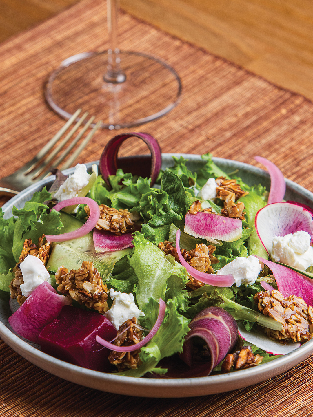 This salad features purple carrot, watermelon radish, cucumber, goat cheese and granola.