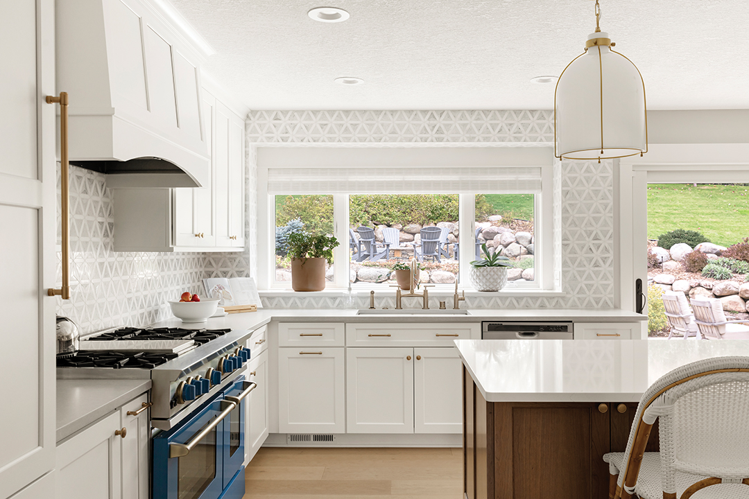 The homeowner thoroughly enjoys cooking and spends the majority of her time in the kitchen. Seeing a newly added window where cupboards once were is “like a dream come true,” the homeowner says. As for its focal point—the Blue Star range—designer Becca Hall says, “The bright blue range was chosen as a striking focal point as well as a high-performance appliance. It offered the perfect blend of professional-level function and a playful, unexpected aesthetic that reflects the homeowners’ style.” The color of the range was chosen “very intentionally,” Hall says, to provide a pop of color without overwhelming the space. “This hue struck that perfect balance—and because it felt so curated and timeless, we carried touches of it into other areas of the home to create a sense of continuity and flow,” she says. Conversely, the darker island grounds a space filled with light. “It balances the vibrant blue range and distributes visual weight, helping the space feel cohesive and well-layered,” Hall says. The homeowner recalls Hall choosing the color and says, “I remember when I first saw the plans—I was so thrilled. But it also scared me a bit to make such a major color statement … I see it every day, and I love it.”