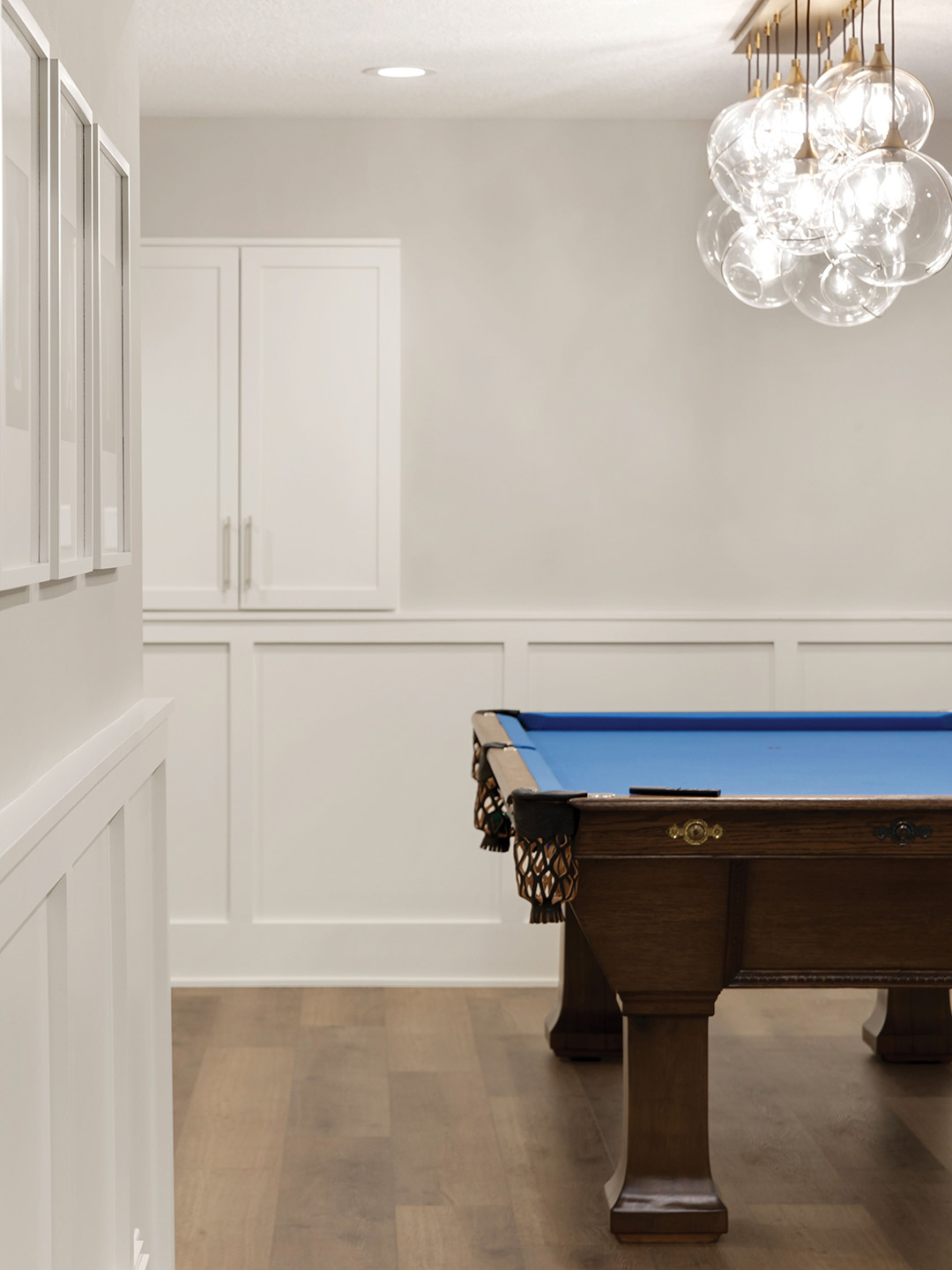 The homeowner explains that designer Becca Hall was able to turn unused space into several different functional areas, including a basement bar, billiards zone, gym and lounge. “I strike the balance by keeping the foundational elements like cabinetry, millwork and flooring consistent with the style of the home and then layering in color, texture and playful accents to bring in personality,” Hall says. “That way, the lower level feels exciting and different but still flows naturally with the rest of the home.”