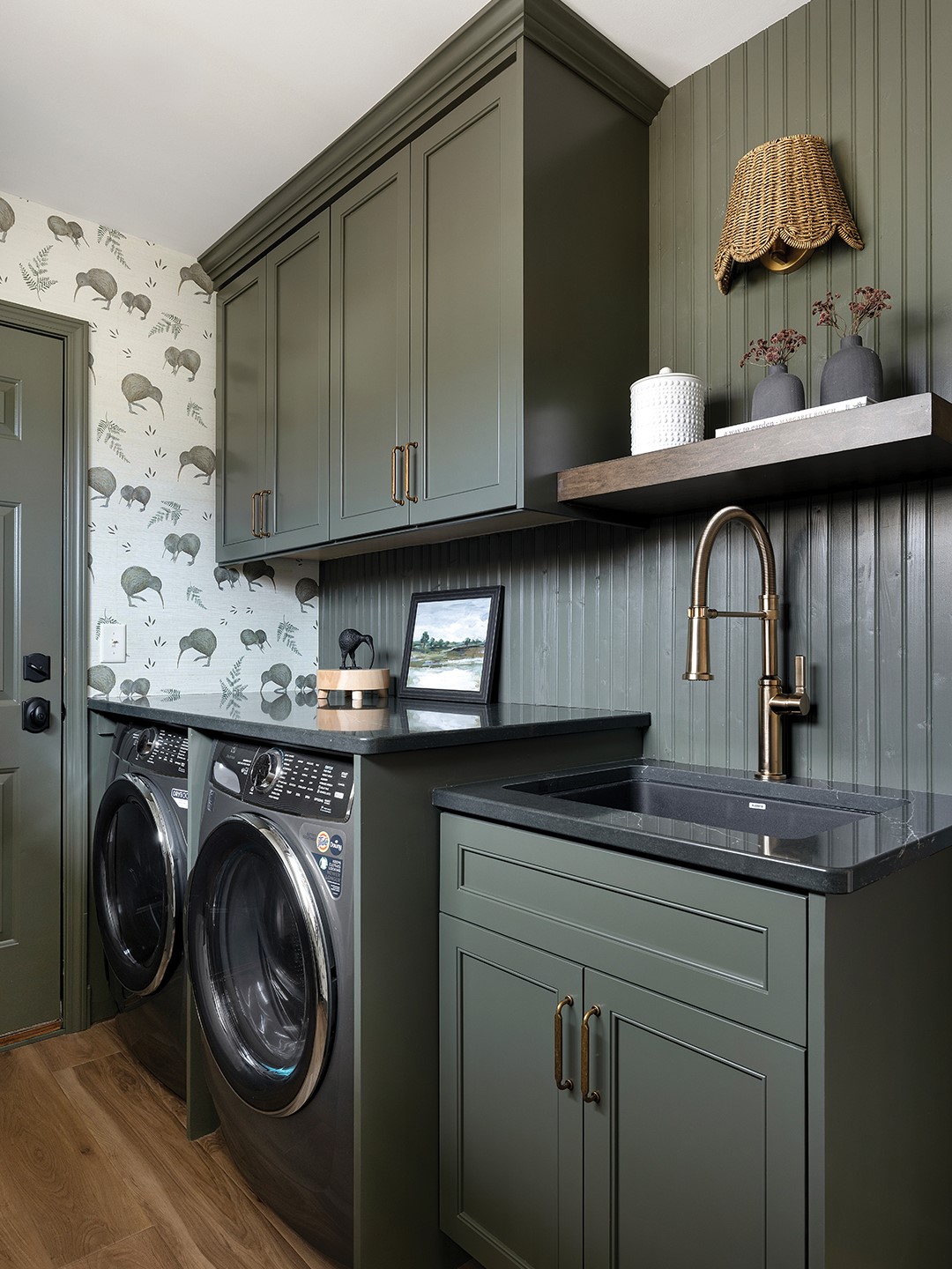 Laundry room with green cabinets and wallpaper